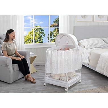 Delta Children Illusions Soothe and Glide Bassinet in Beige. View a larger version of this product image.