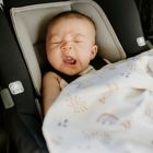 Alternate image 1 for Little Unicorn Rainbows and Raindrops Deluxe Muslin Baby Receiving Quilt in Purple/White