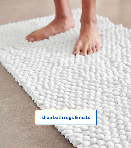 Person standing on a white chunky bath rug from the Haven collection.