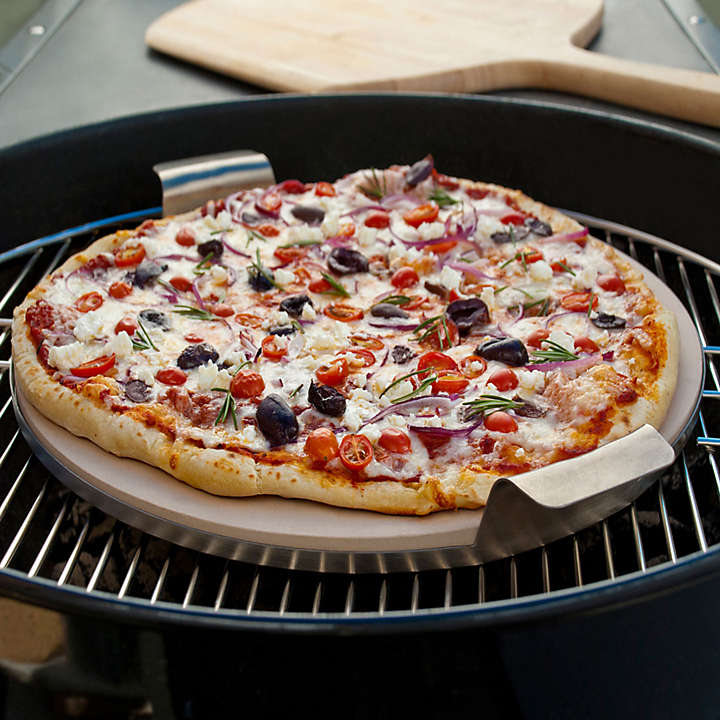 a pizza cooks on a grill