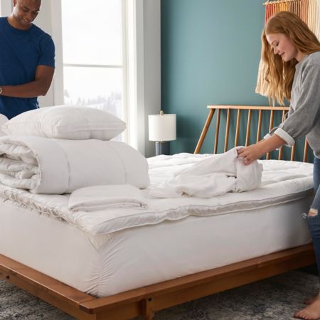 a man and a woman make a bed