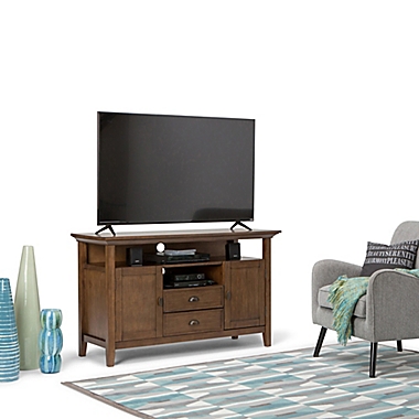 Simpli Home&trade; Redmond Solid Wood Tall TV Media Stand in Rustic Natural Aged Brown. View a larger version of this product image.