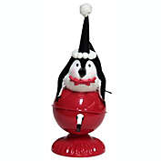 Melrose 10.5" Playful Glittered Black and White Penquin Laying on Large Red Jingle Bell Christmas Table Top Decoration